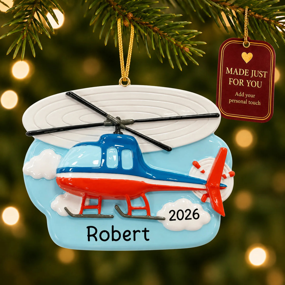 Helicopter christmas ornament hanging on a lit Christmas tree with a Made Just For You gift tag