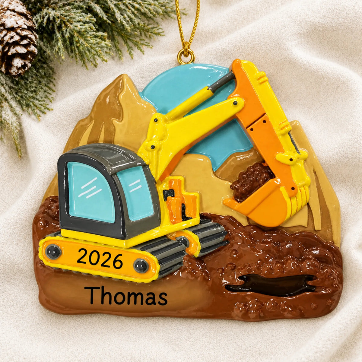 Personalized digger christmas ornament laid on a soft white knit blanket
