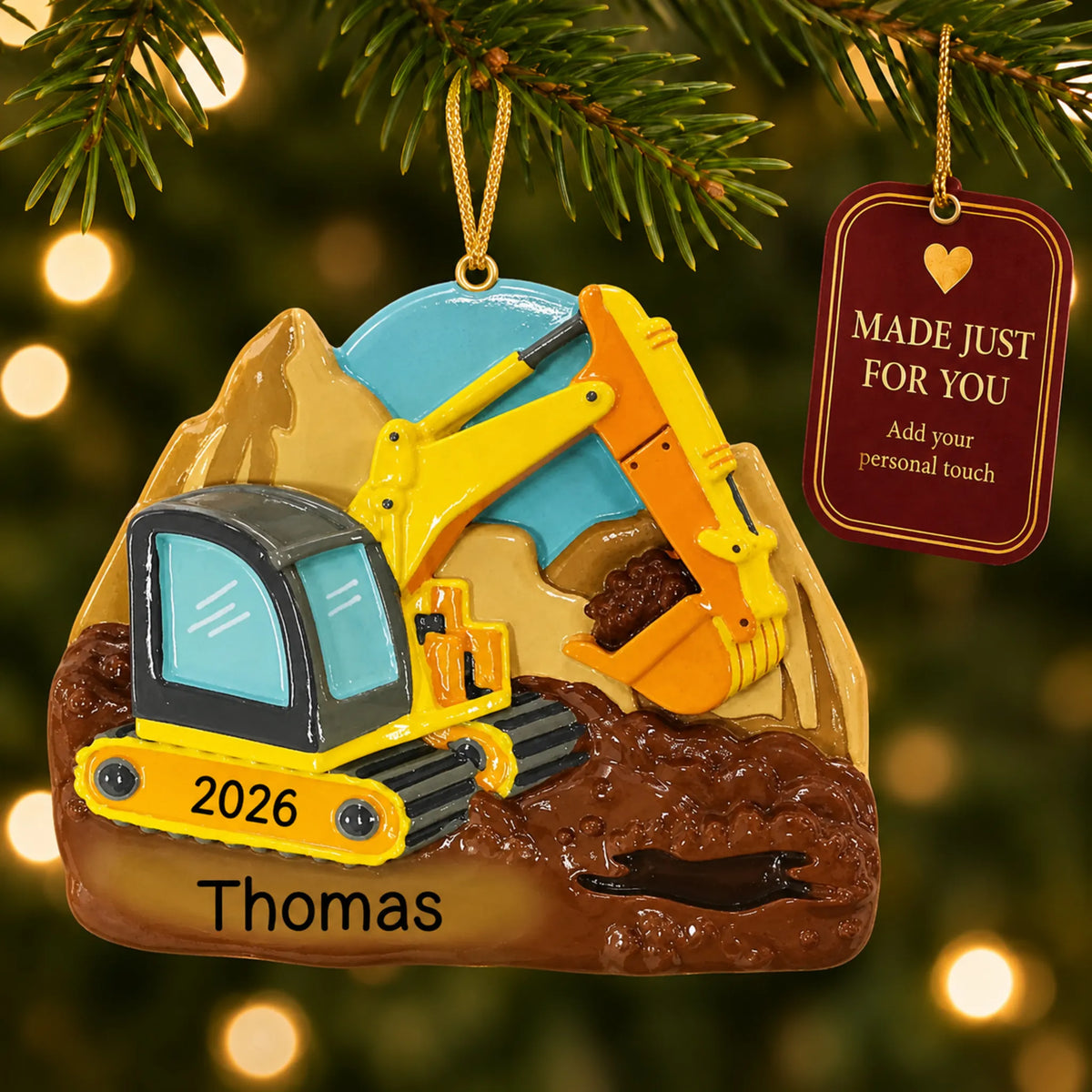 Digger christmas ornament hanging on a lit Christmas tree with a Made Just For You gift tag