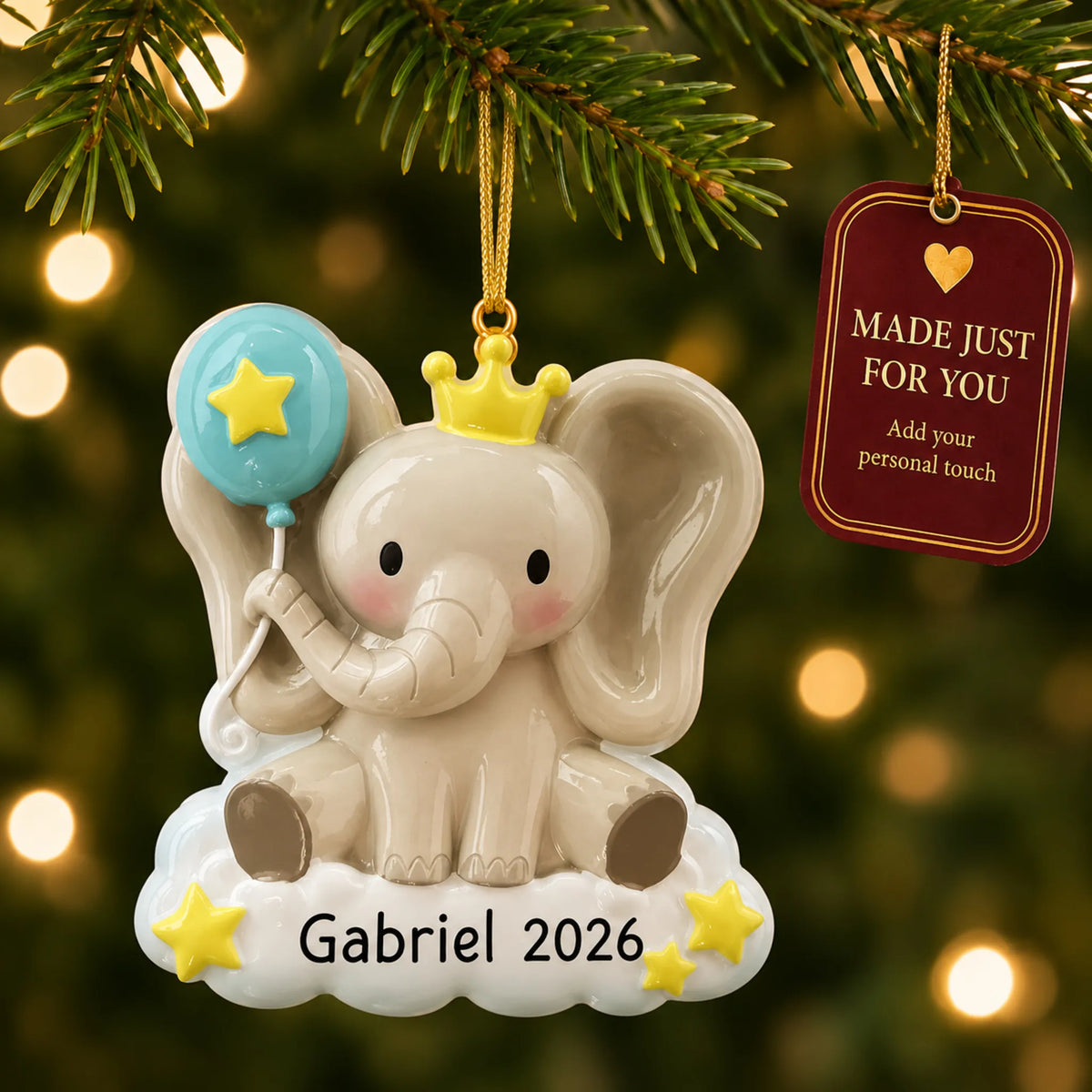 Baby boy elephant christmas ornament hanging on a lit Christmas tree with a Made Just For You gift tag