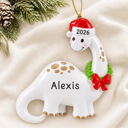 Personalized white dinosaur christmas ornament laid on a soft white knit blanket