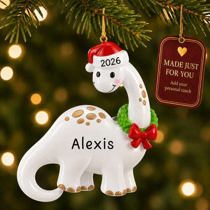 White dinosaur christmas ornament hanging on a lit Christmas tree with a Made Just For You gift tag