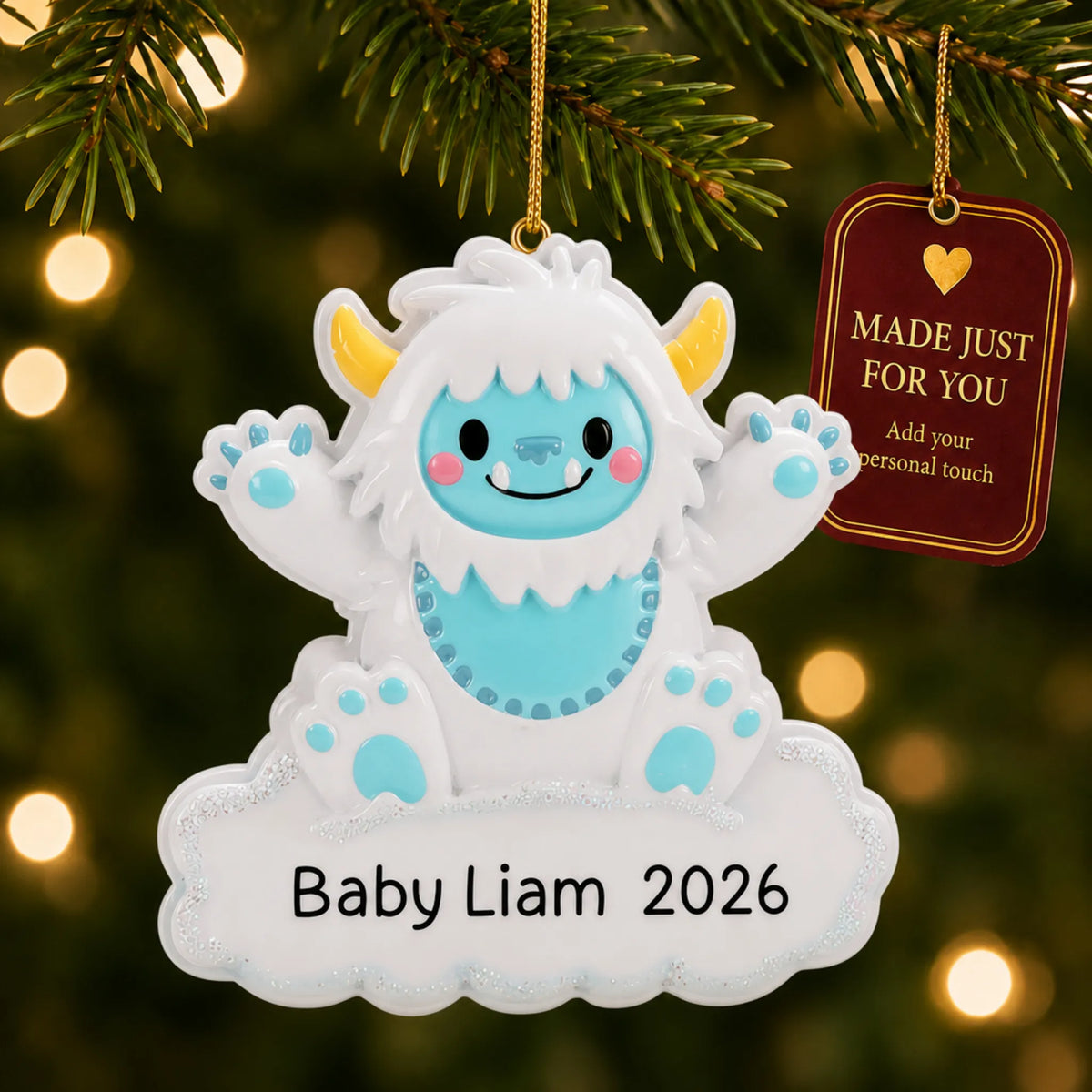 Blue baby boy yeti christmas ornament hanging on a lit Christmas tree with a Made Just For You gift tag