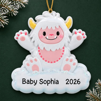 Personalized pink baby girl yeti christmas ornament on a dark green pine background