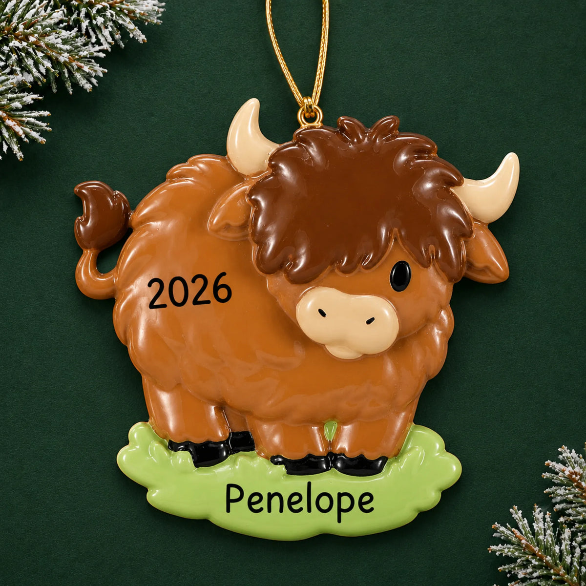 Personalized highland cow christmas ornament on a dark green pine background