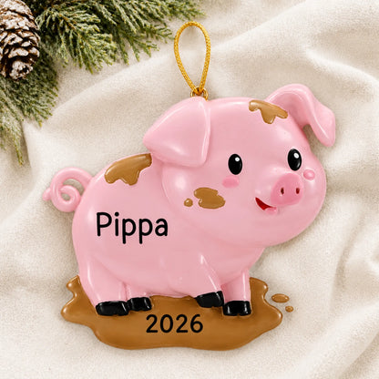 Personalized pig christmas ornament laid on a soft white knit blanket