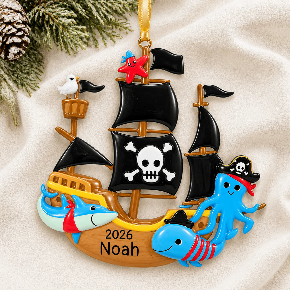 Personalized pirate ship christmas ornament laid on a soft white knit blanket