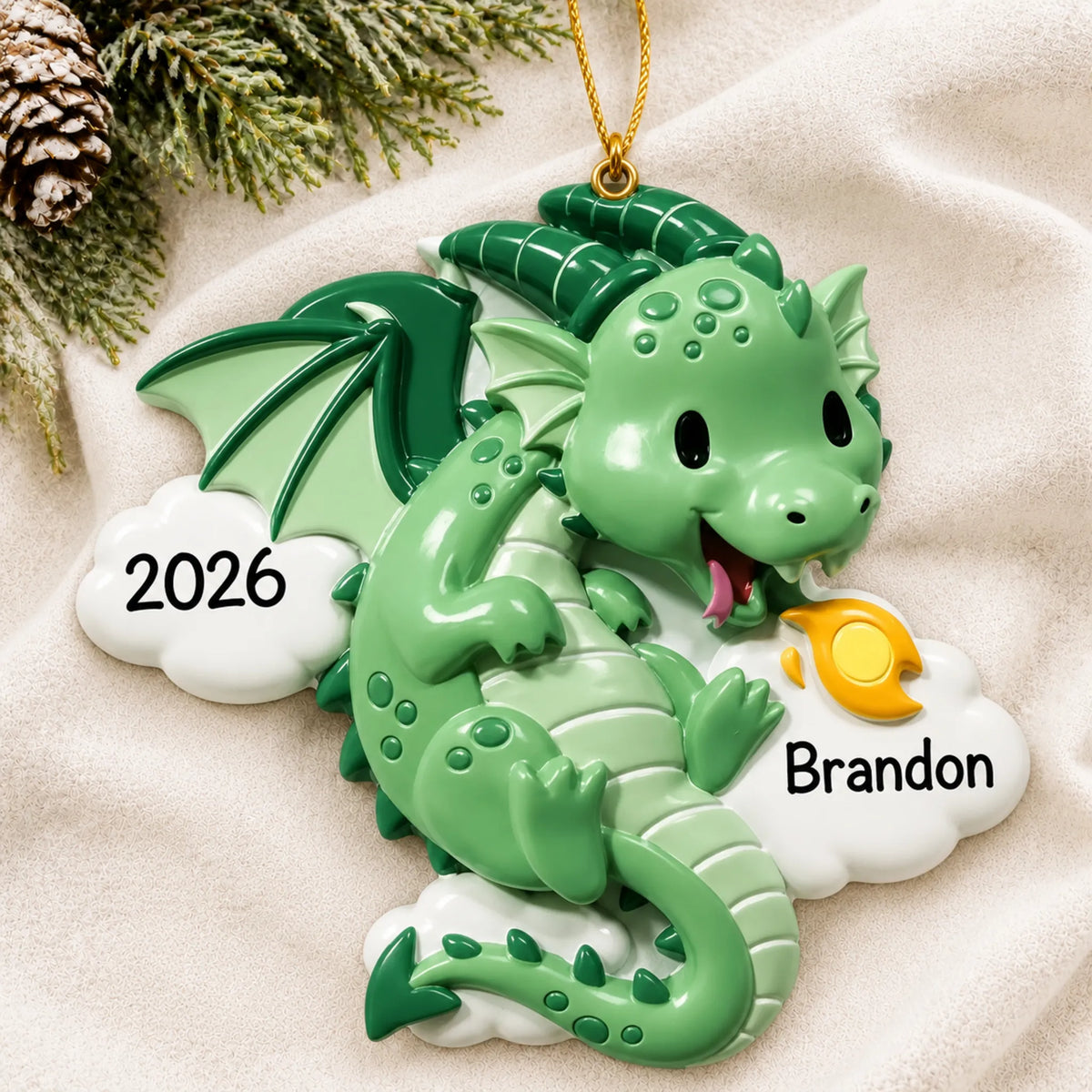 Personalized green dragon christmas ornament laid on a soft white knit blanket