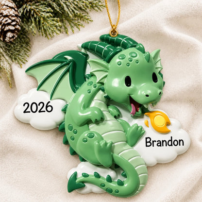 Personalized green dragon christmas ornament laid on a soft white knit blanket