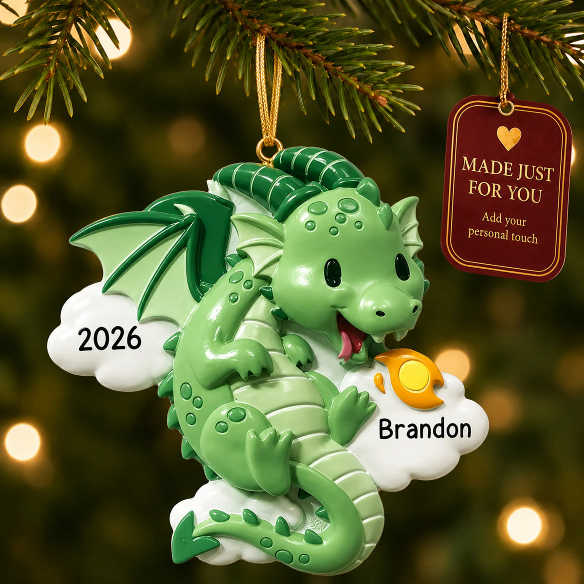 Green dragon christmas ornament hanging on a lit Christmas tree with a Made Just For You gift tag