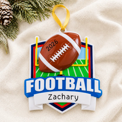 Personalized football collage christmas ornament laid on a soft white knit blanket