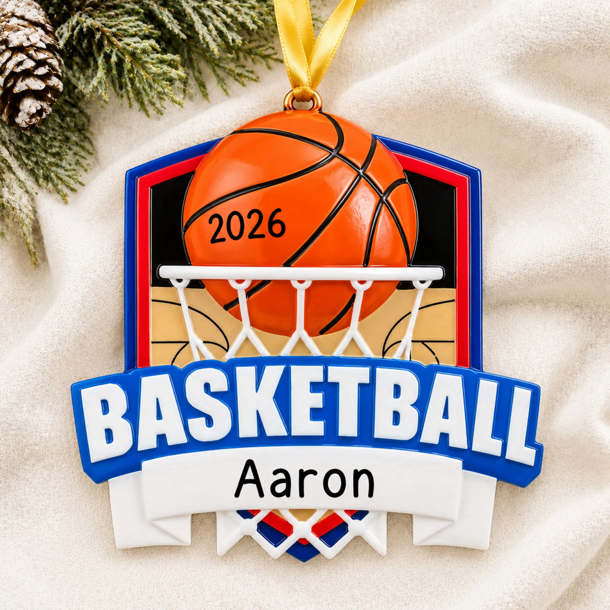 Personalized basketball shield christmas ornament laid on a soft white knit blanket
