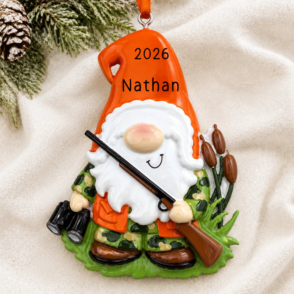 Personalized hunting gnome christmas ornament laid on a soft white knit blanket