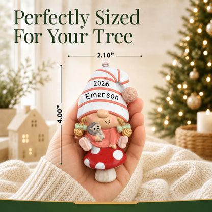 Size guide: the personalized baby girl gnome christmas ornament is 2.10 in wide by 4.00 in tall, shown in hand