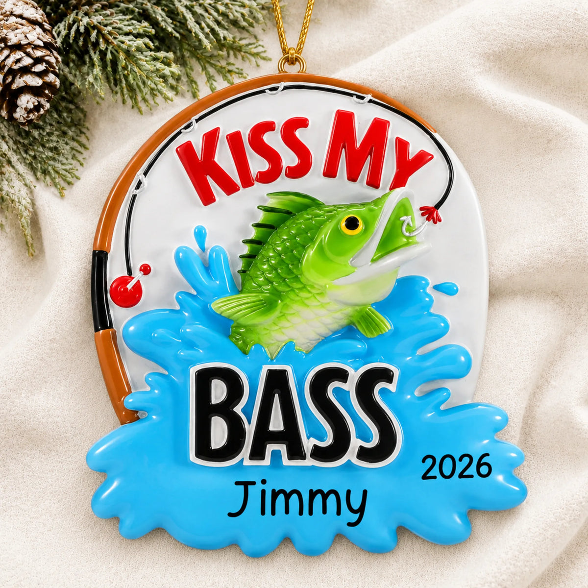 Personalized kiss my bass fishing christmas ornament laid on a soft white knit blanket