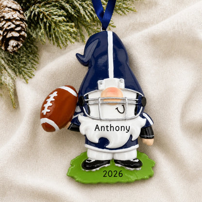 Personalized gnome football player christmas ornament laid on a soft white knit blanket