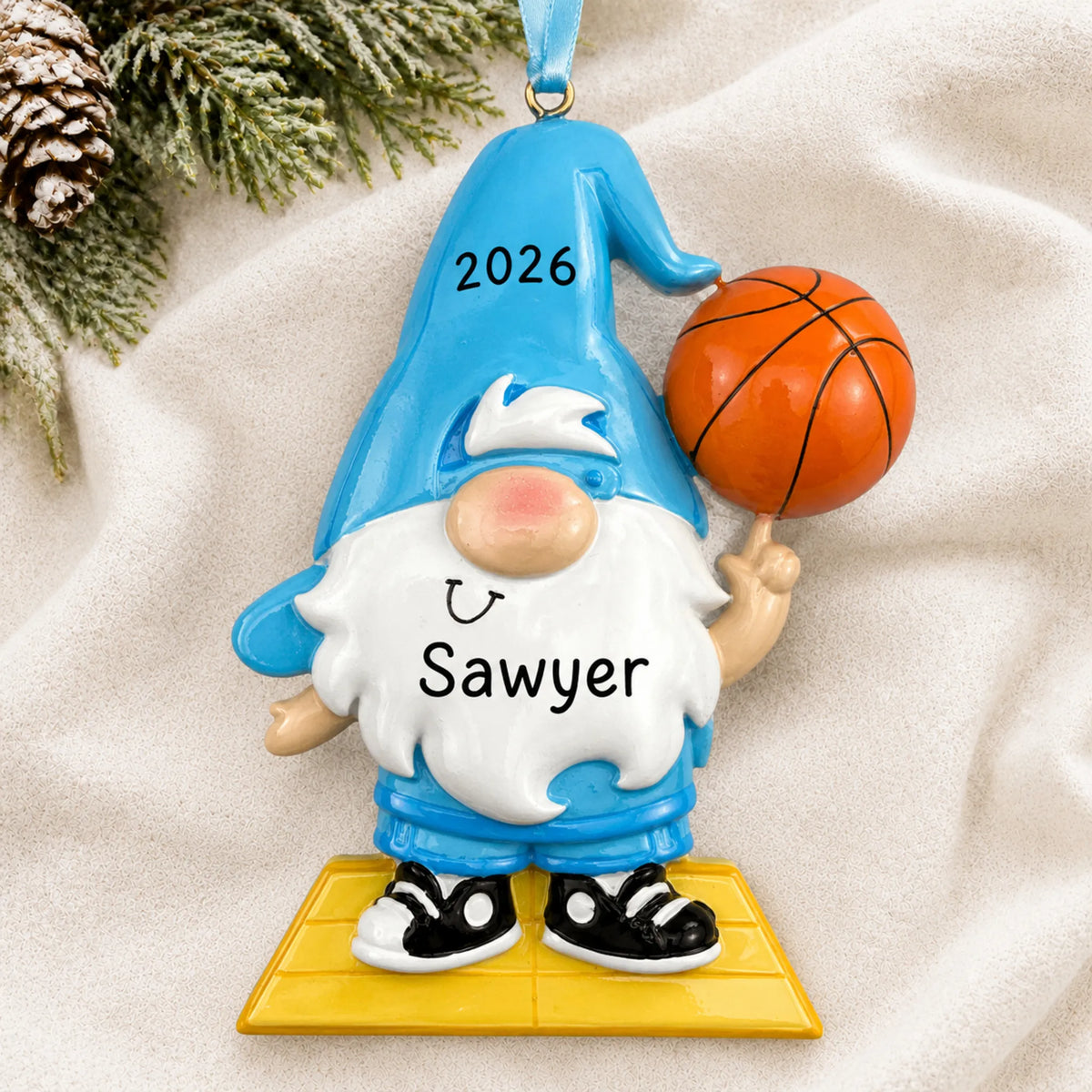 Personalized basketball gnome christmas ornament laid on a soft white knit blanket
