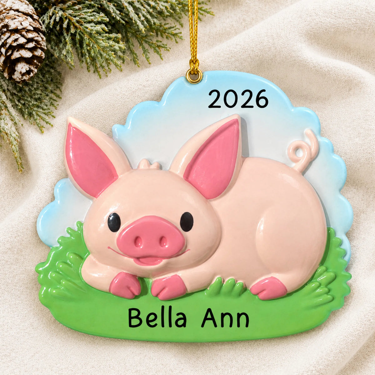 Personalized cute pig christmas ornament laid on a soft white knit blanket