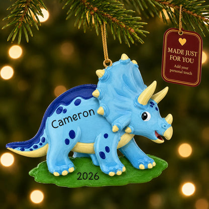Blue triceratops dinosaur christmas ornament hanging on a lit Christmas tree with a Made Just For You gift tag