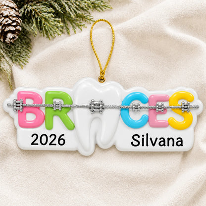 Personalized braces christmas ornament laid on a soft white knit blanket