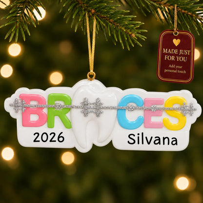 Braces christmas ornament hanging on a lit Christmas tree with a Made Just For You gift tag