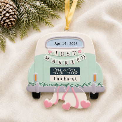 Personalized mint Just Married car Christmas ornament on a cream knit blanket beside pine and pinecones