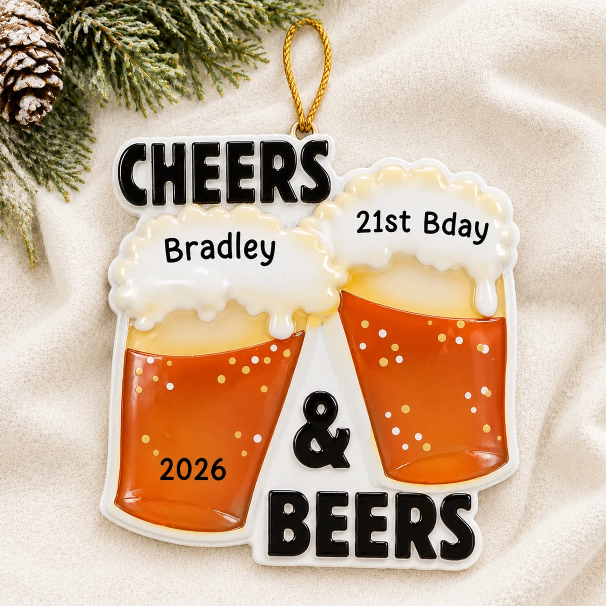 Personalized Cheers & Beers christmas ornament laid on a soft white knit blanket