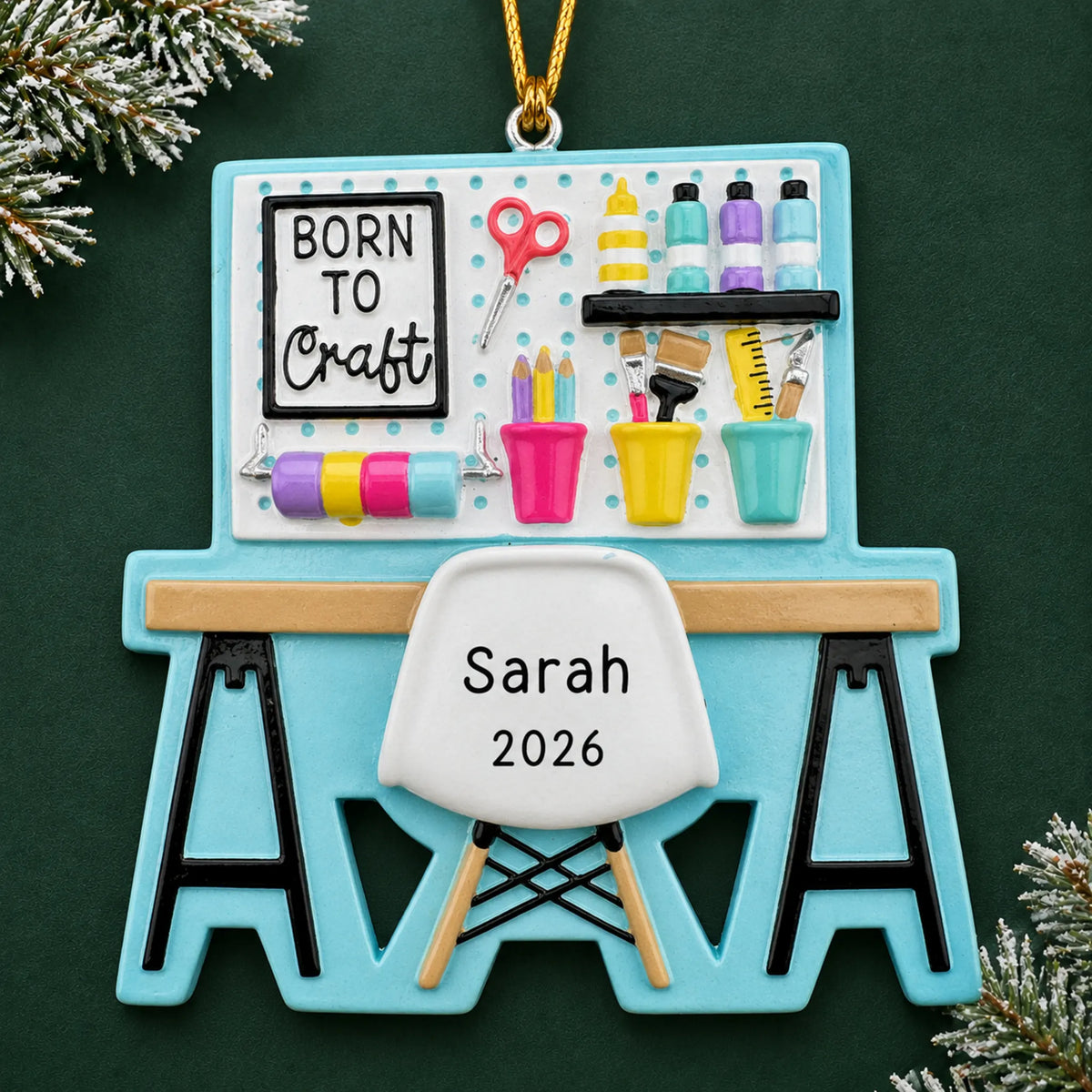 Personalized arts and crafts table christmas ornament on a dark green pine background