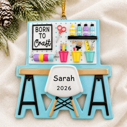 Personalized arts and crafts table christmas ornament laid on a soft white knit blanket