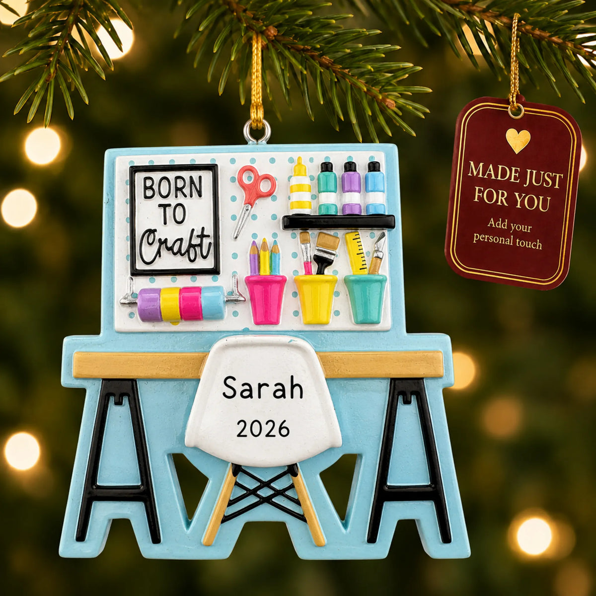 Arts and crafts table christmas ornament hanging on a lit Christmas tree with a Made Just For You gift tag