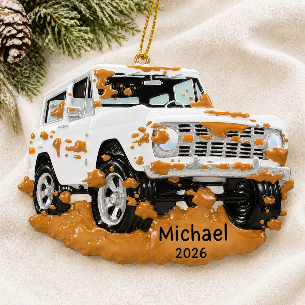 Personalized Off-Road Truck christmas ornament laid on a soft white knit blanket