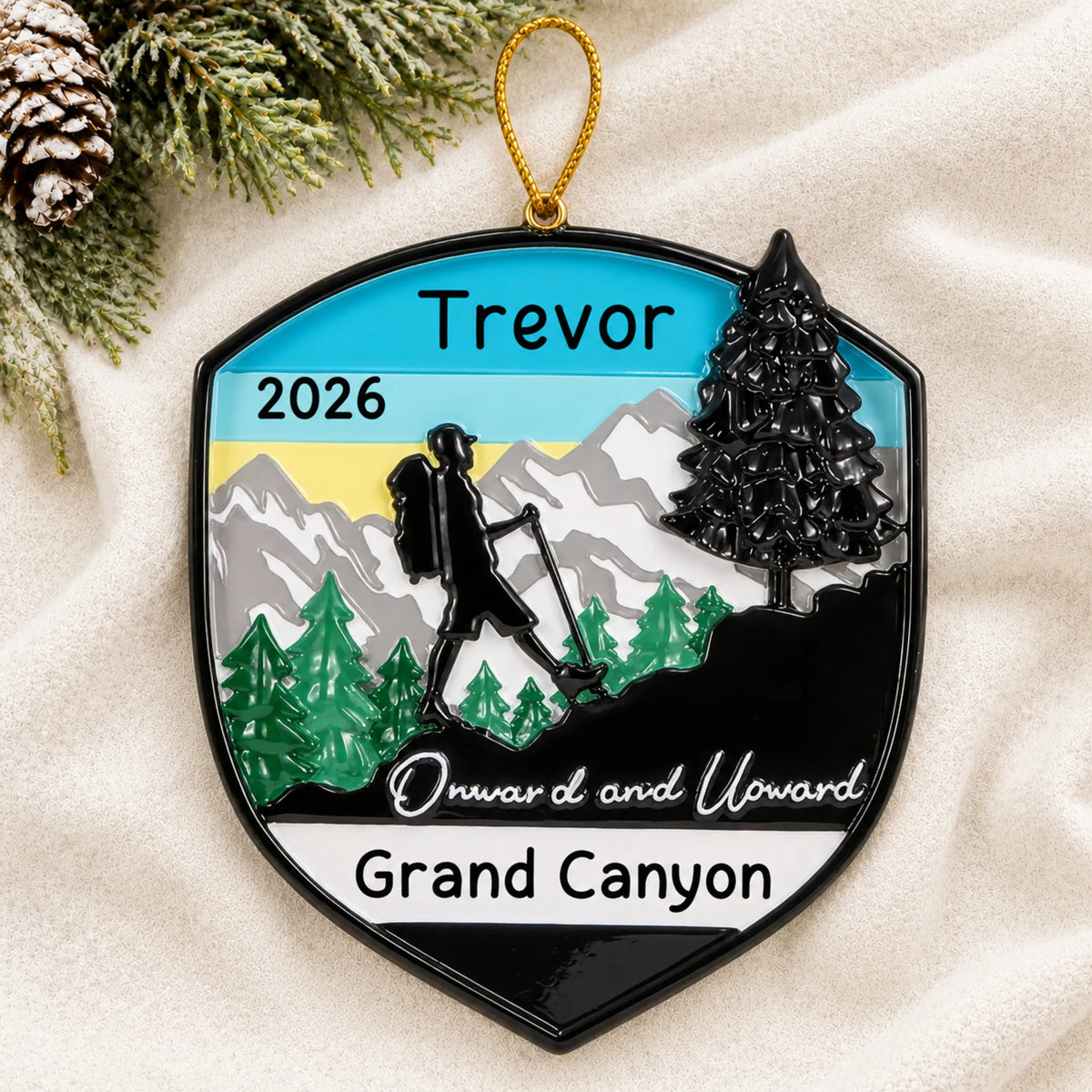 Personalized hiking adventure christmas ornament laid on a soft white knit blanket