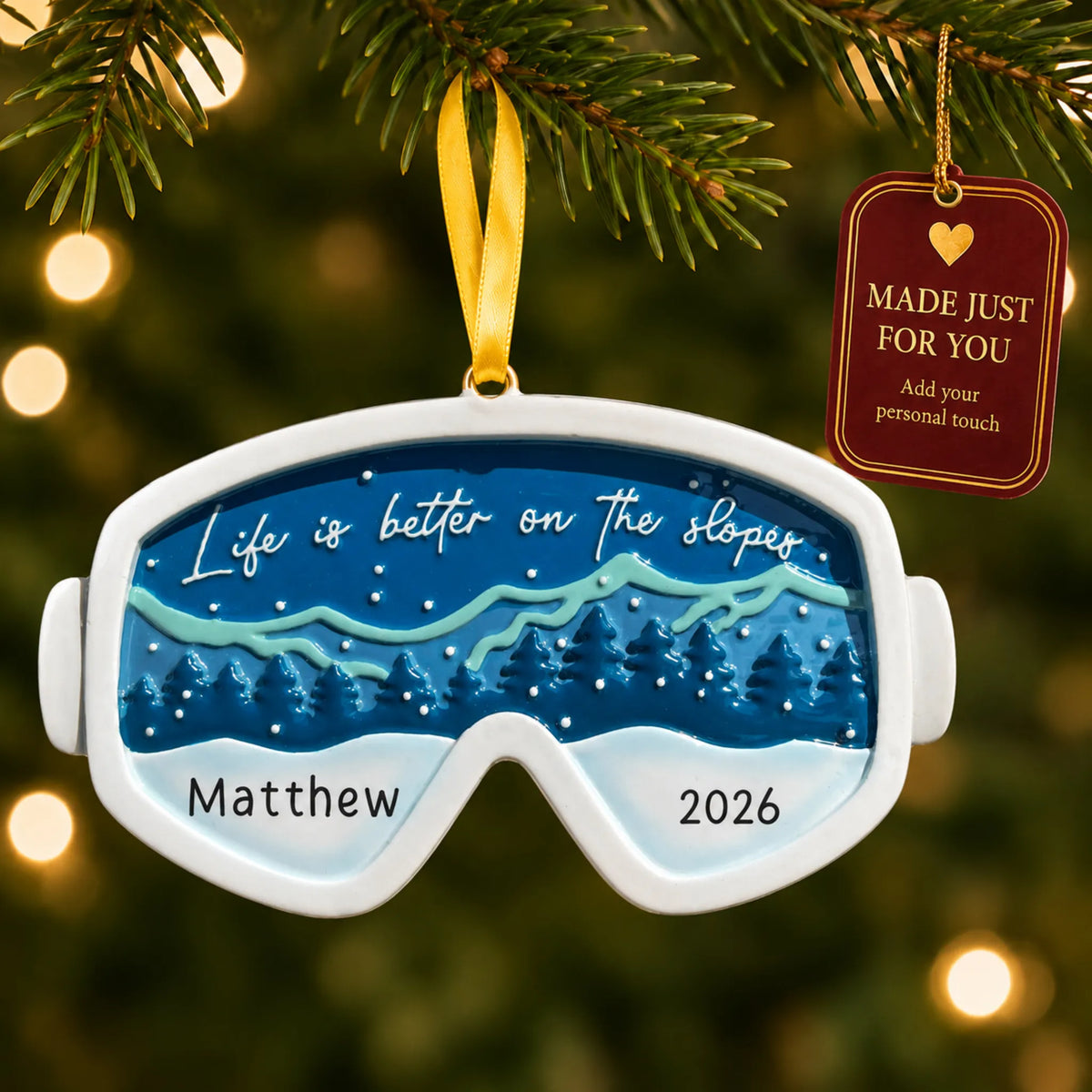 Ski goggles christmas ornament hanging on a lit Christmas tree with a Made Just For You gift tag