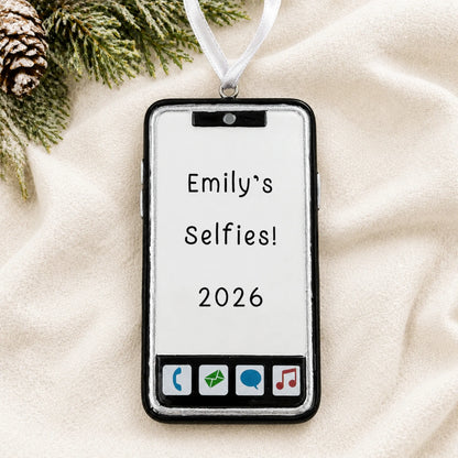 Personalized smartphone christmas ornament laid on a soft white knit blanket