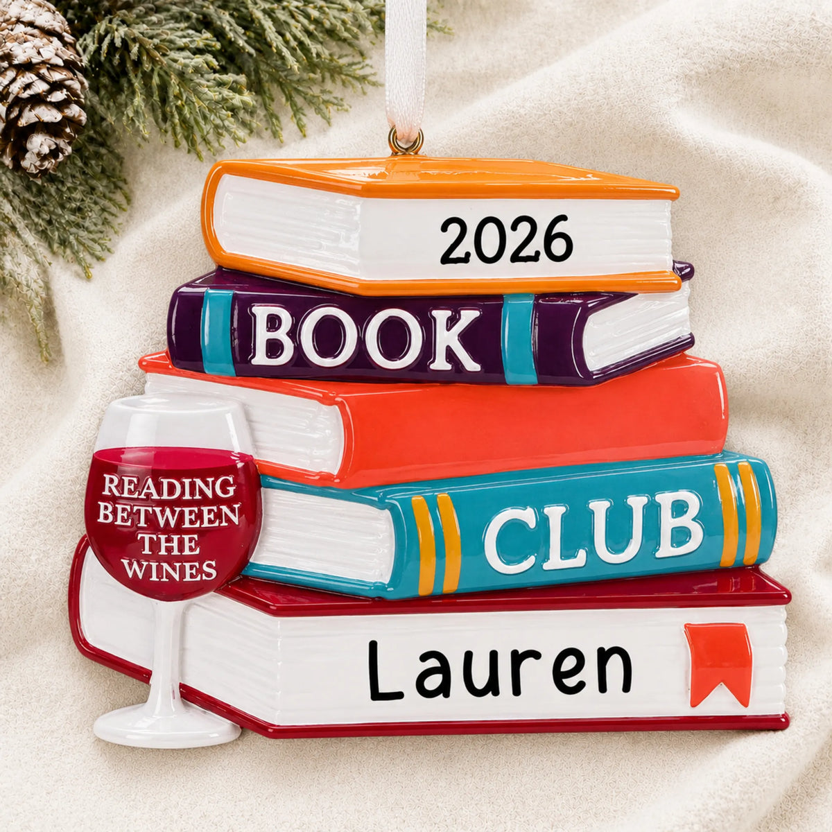 Personalized Book Club Wine Glass christmas ornament laid on a soft white knit blanket