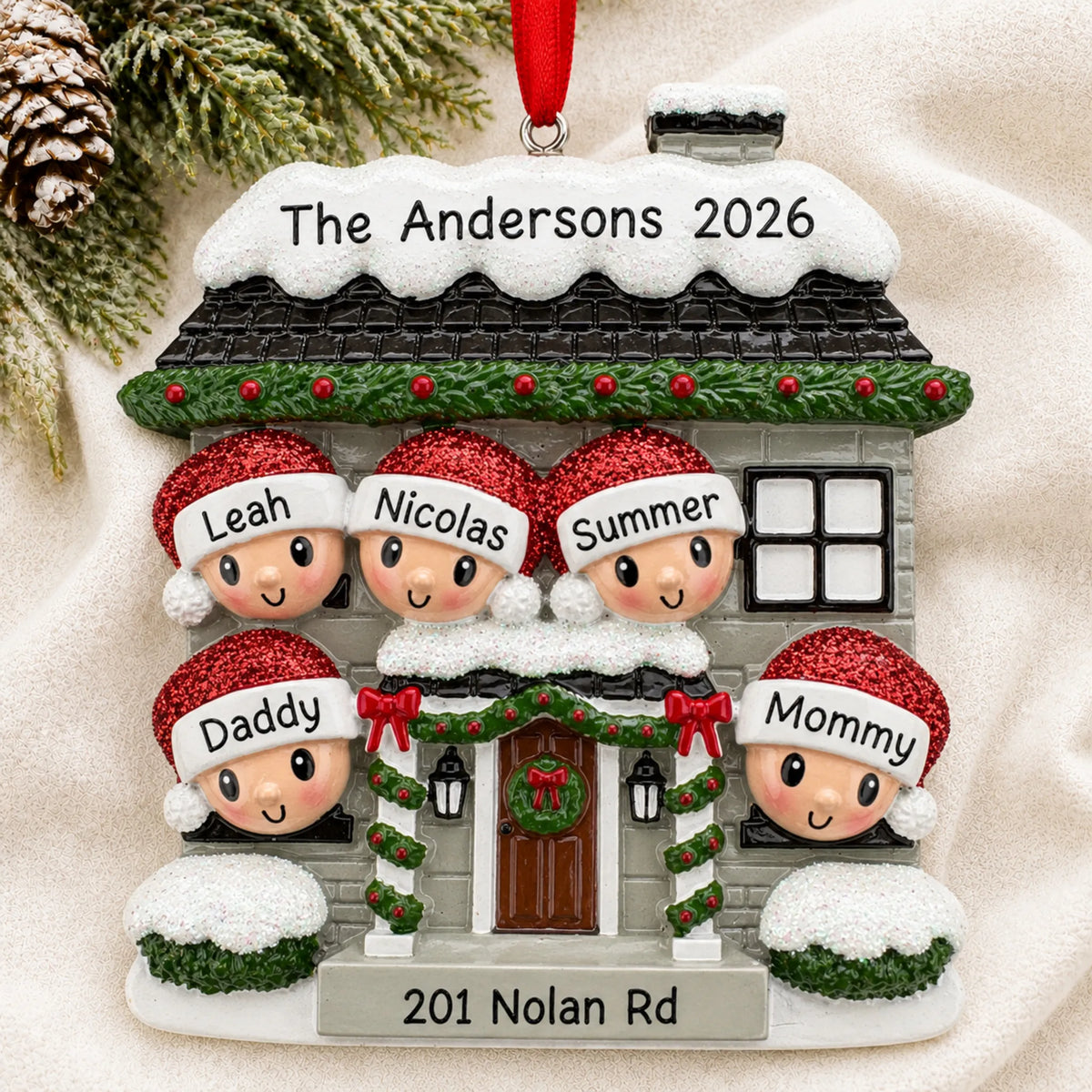 Personalized new home family of 5 christmas ornament laid on a soft white knit blanket