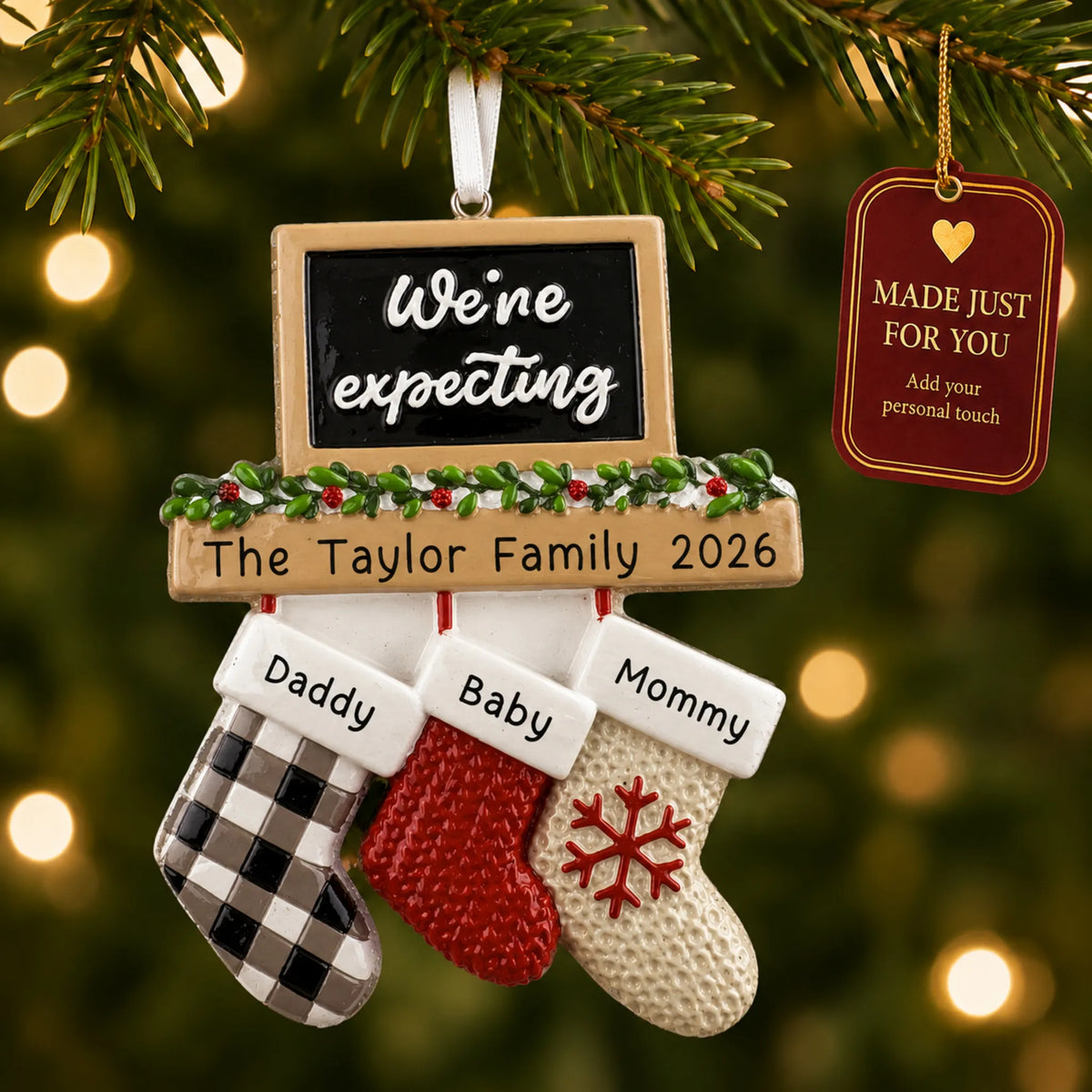 We're Expecting Couple's christmas ornament hanging on a lit Christmas tree with a Made Just For You gift tag