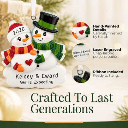 Hand-painted details and laser engraved personalization on the Expecting Snowman Couple christmas ornament, ribbon included