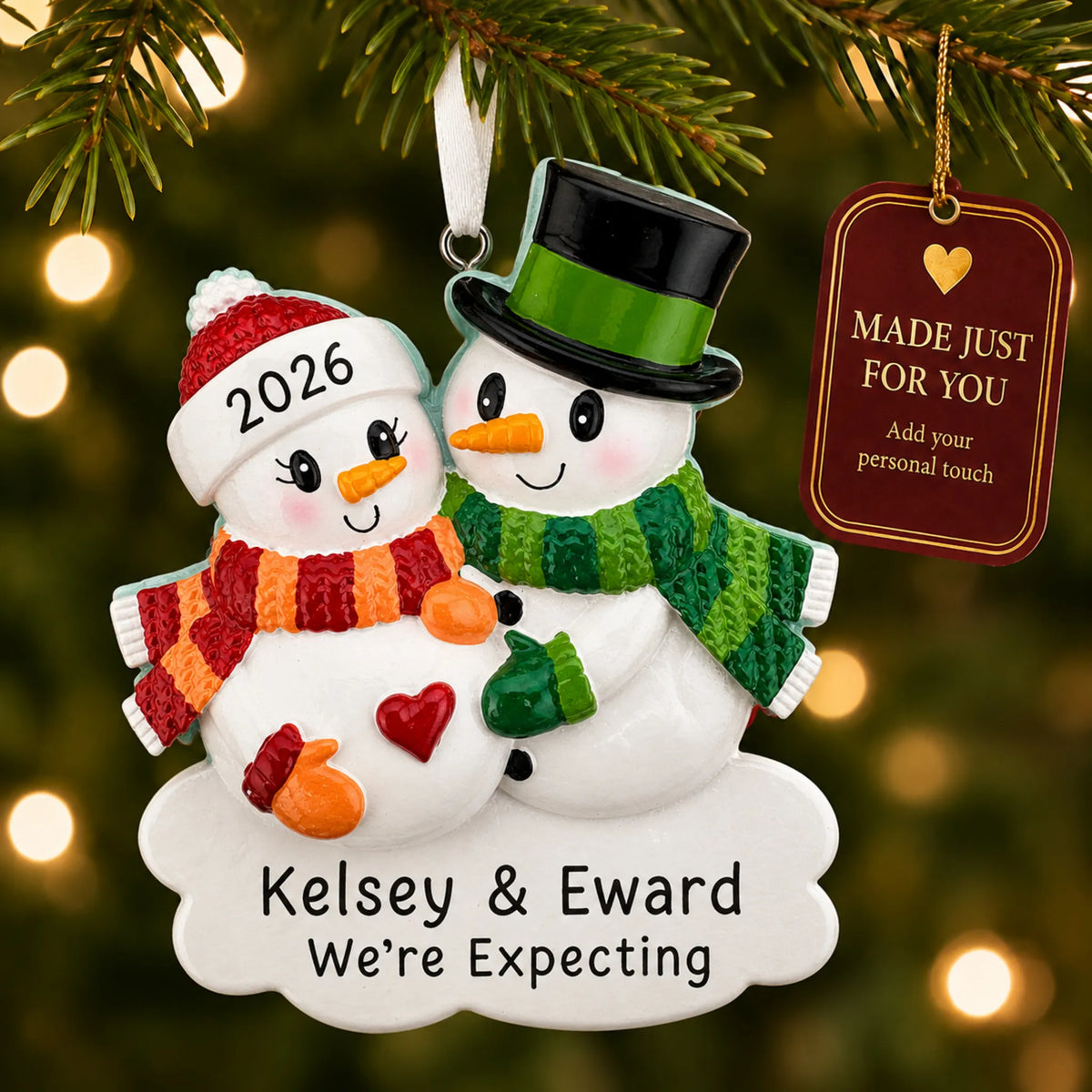 Expecting Snowman Couple christmas ornament hanging on a lit Christmas tree with a Made Just For You gift tag