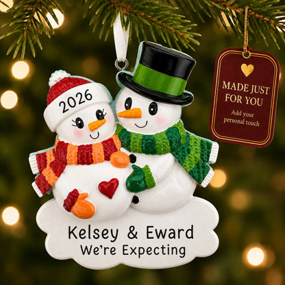 Expecting Snowman Couple christmas ornament hanging on a lit Christmas tree with a Made Just For You gift tag