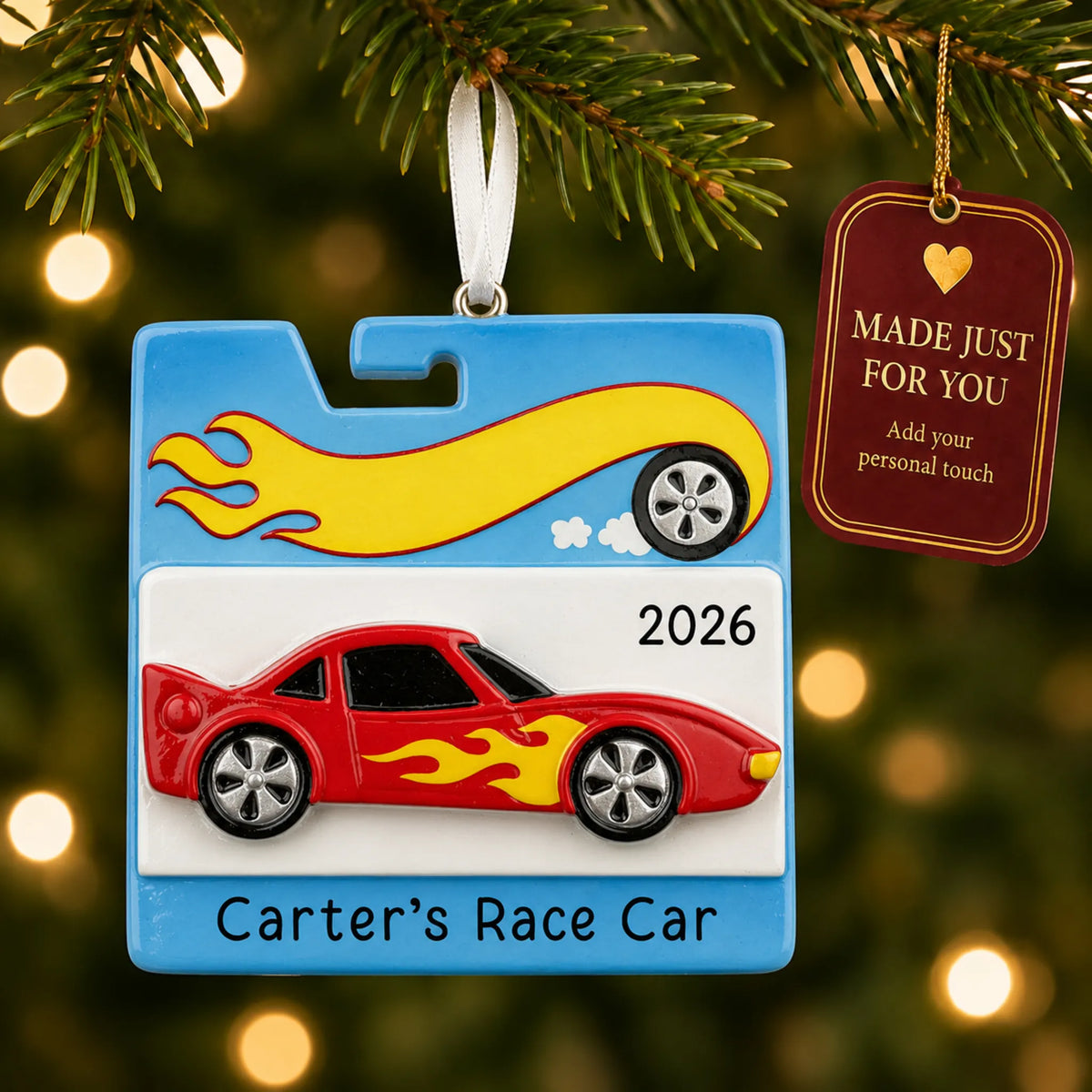 Race car christmas ornament hanging on a lit Christmas tree with a Made Just For You gift tag