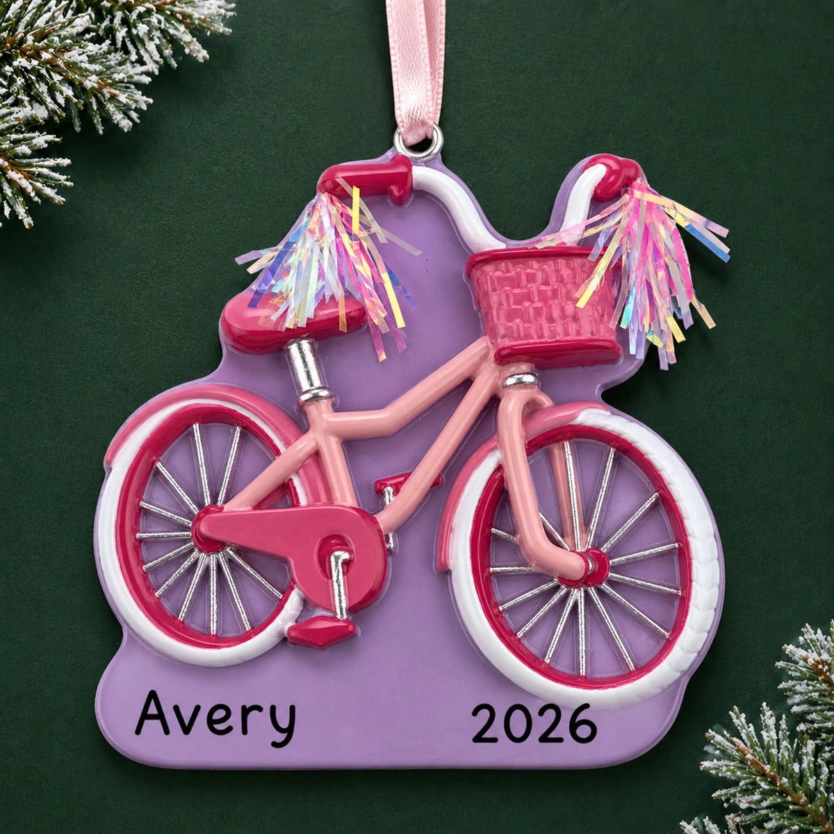 Personalized girl's first bike christmas ornament on a dark green pine background