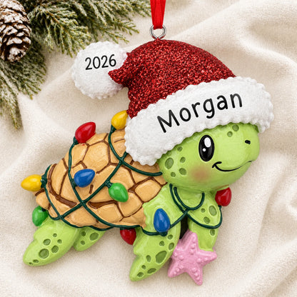 Personalized festive sea turtle christmas ornament laid on a soft white knit blanket