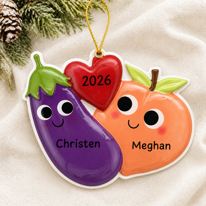 Personalized Eggplant & Peach christmas ornament laid on a soft white knit blanket