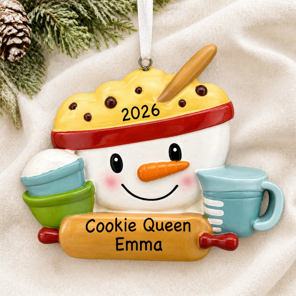 Personalized baking measuring cups christmas ornament laid on a soft white knit blanket