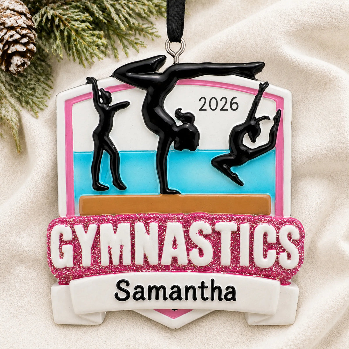 Personalized Gymnastics Meet christmas ornament laid on a soft white knit blanket