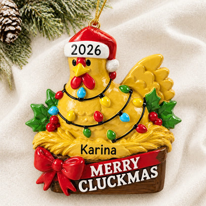 Personalized merry cluckmas chicken christmas ornament laid on a soft white knit blanket