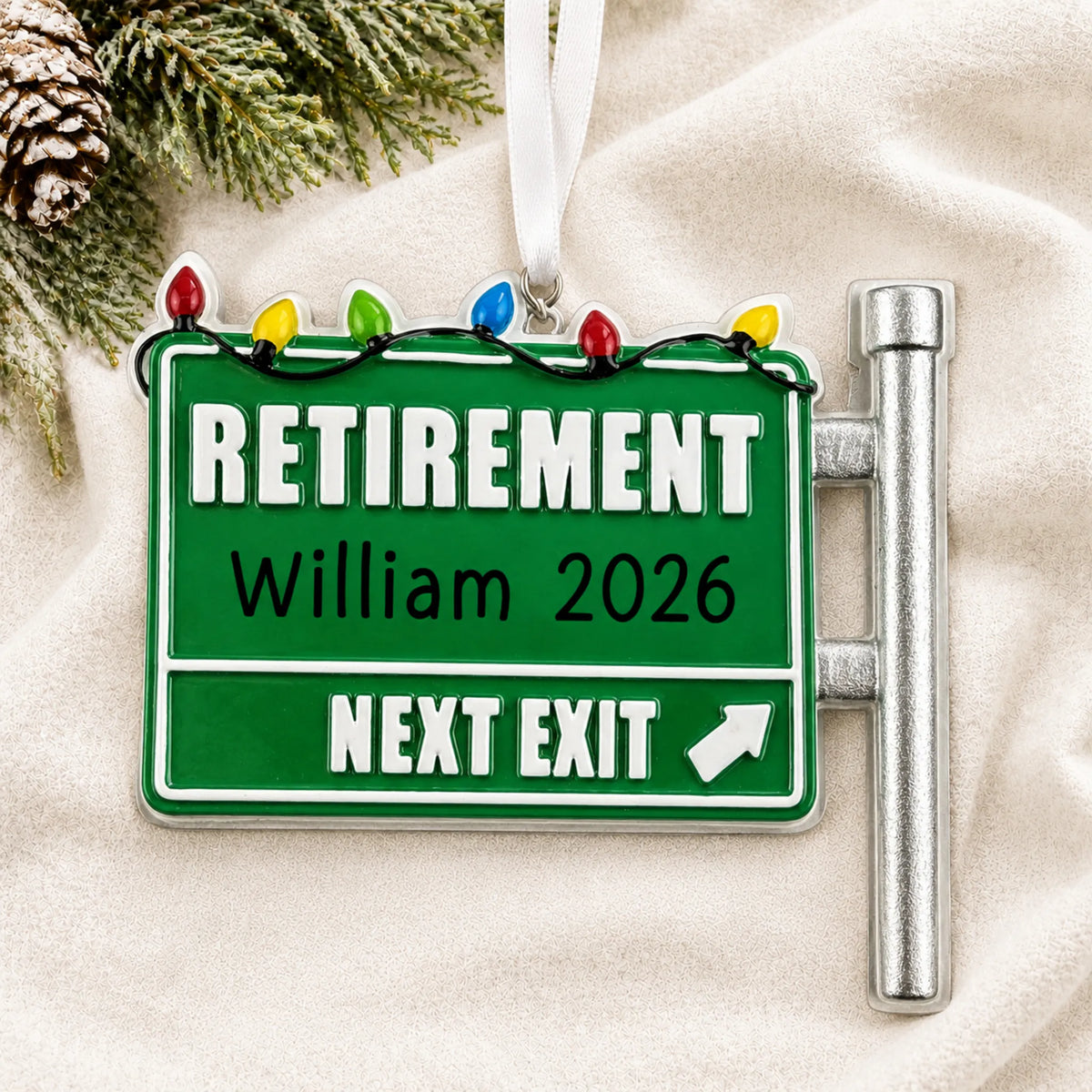 Personalized retirement christmas ornament laid on a soft white knit blanket