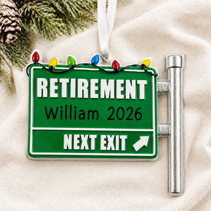 Personalized retirement christmas ornament laid on a soft white knit blanket