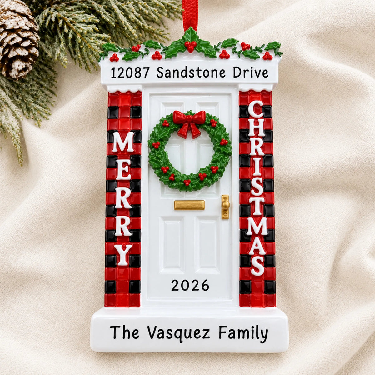 Personalized Merry Christmas Door ornament laid on a soft white knit blanket